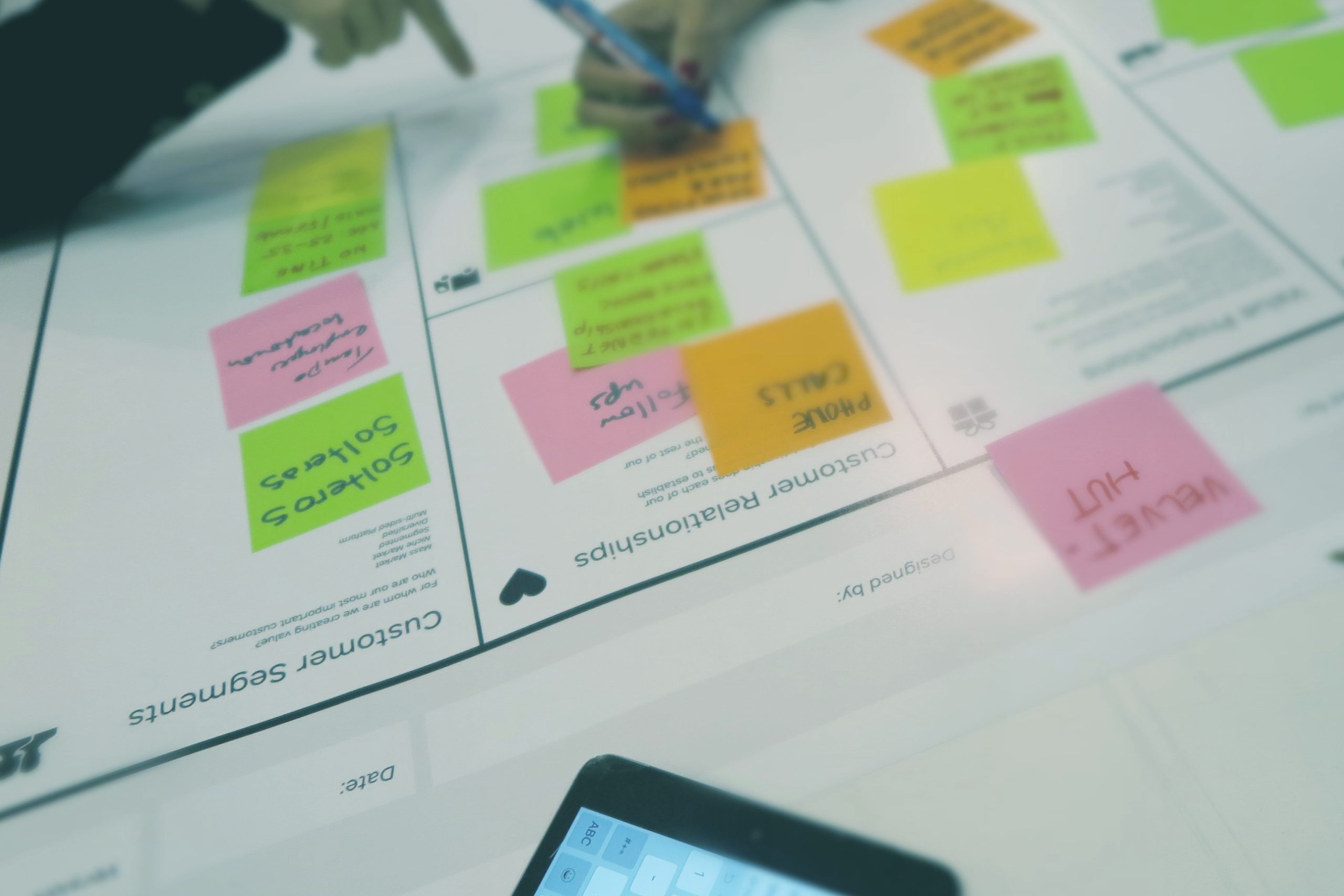 A large piece of paper with colorful sticky notes placed in chart boxes.