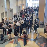 dozens of people mingle in the large room