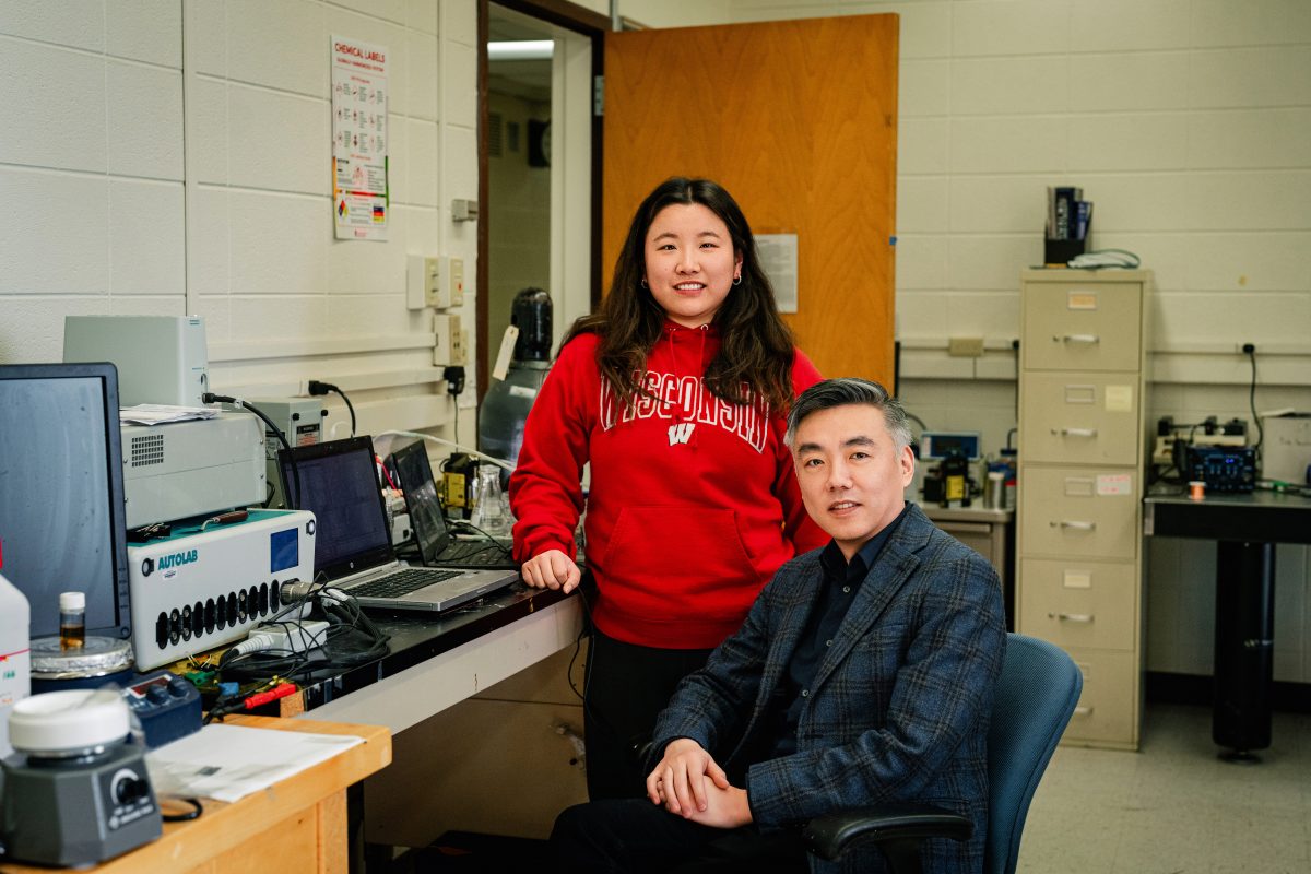 Asian woman with long brown hair standing next to an Asian man with short black hair.