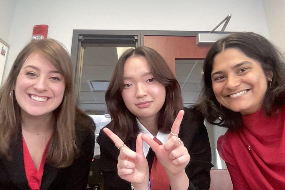 three women pose with the Wisconsin W hand symbol