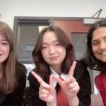 three women pose with the Wisconsin W hand symbol