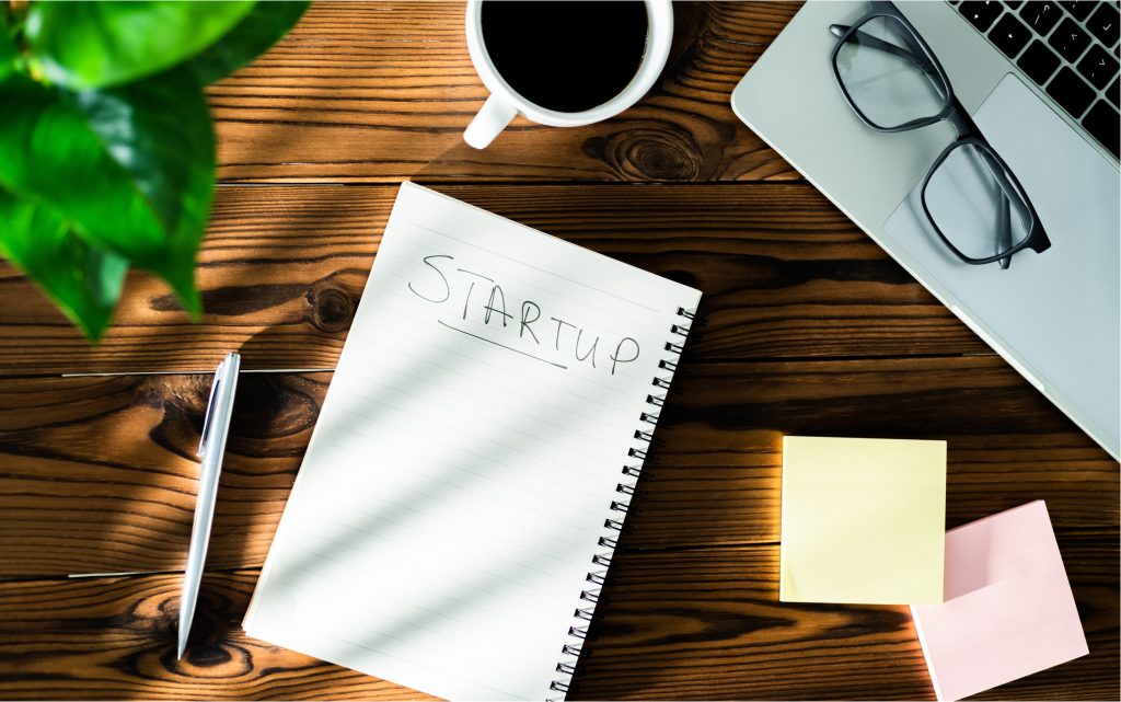 notebook on a desk that reads "startup"