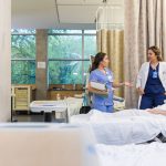 nurse, doctor, and patient in conversation around bedside