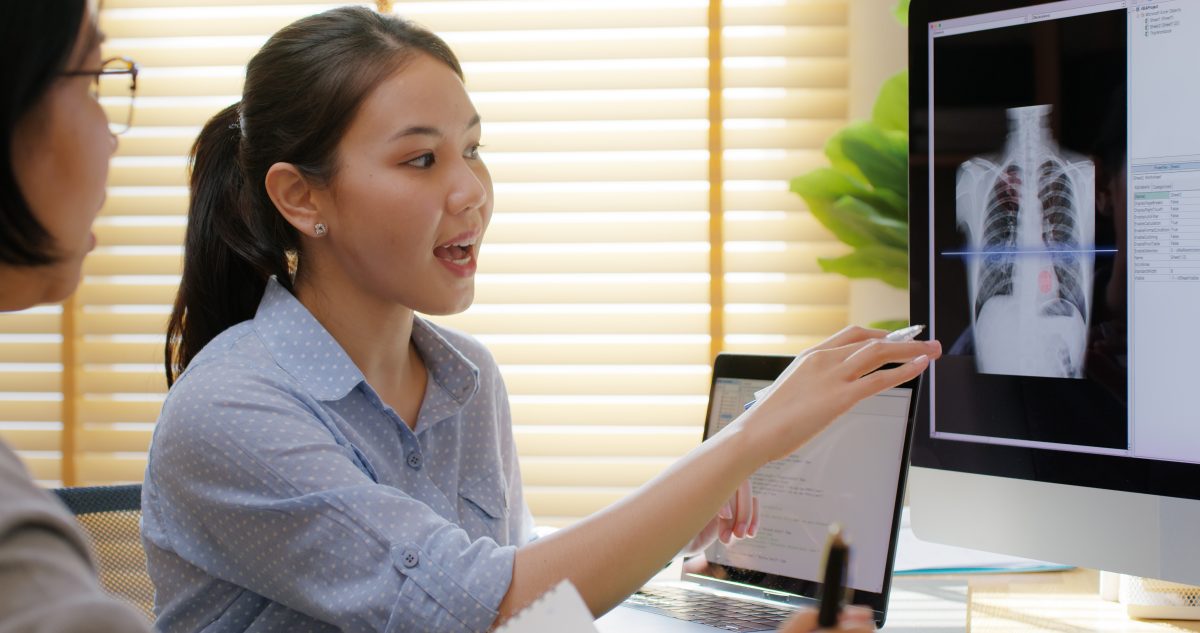 woman pointing to a screen with an xray